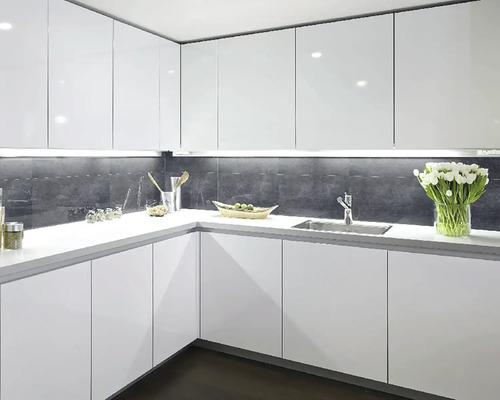 Svetlá kuchyňa s bielymi skrinkami, umývadlom a pracovnou doskou