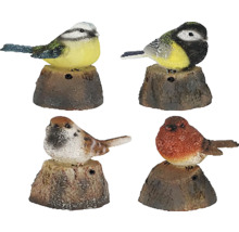 Štyri ozdobné záhradné vtáky na pňoch stromov