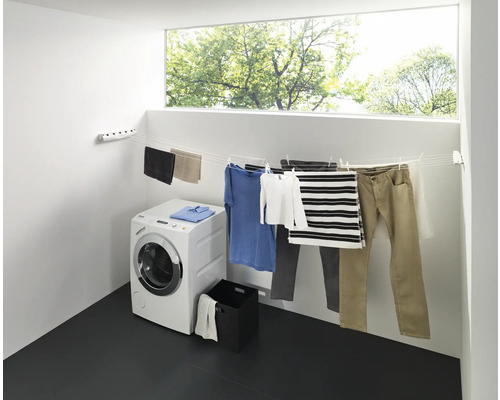 Sušiak na bielizeň s bielizňou, práčka a okno vo svetlej miestnosti