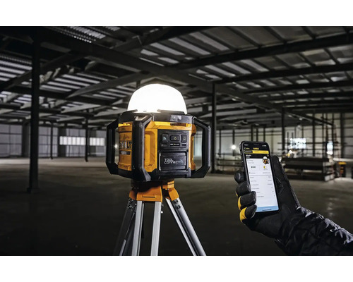 Pracovná lampa DeWalt so statívom a ovládaním pomocou inteligentného telefónu v továrnej hale
