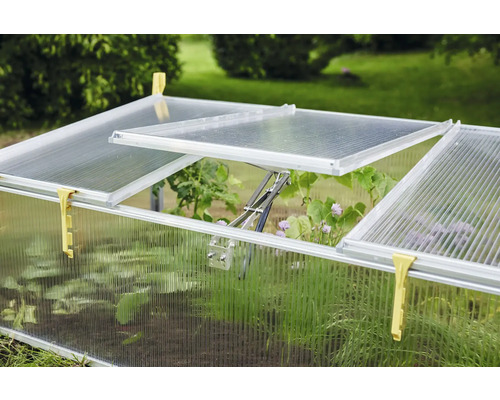 Parenisko s priehľadnými stenami a otvorenými oknami v záhrade