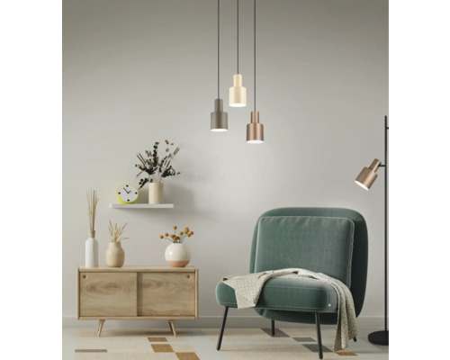 Obývacia izba s kreslom, komodou, závesnými svietidlami a stojacou lampou pre svetlú a príjemnú atmosféru