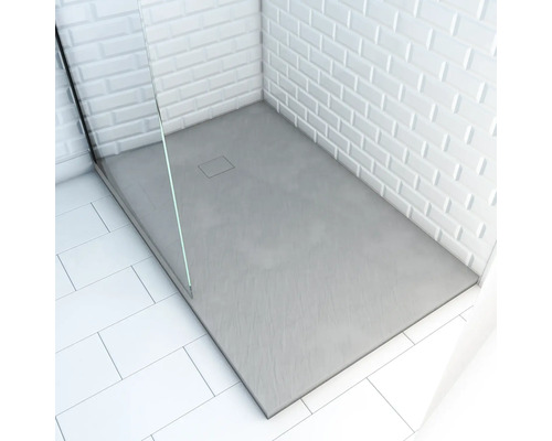 Bezbariérový sprchovací kút s obdĺžnikovou sprchovacou vaničkou, sklenenou sprchovacou zástenou a bielymi obkladačkami metra.