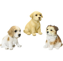 Tri sediace figúrky šteniat ako záhradná dekorácia