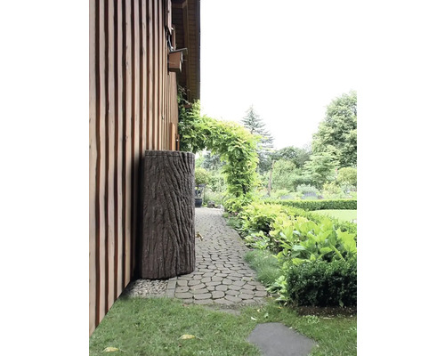 Záhrada s dažďovou nádržou, ktorá vyzerá ako kmeň stromu, vedľa domu