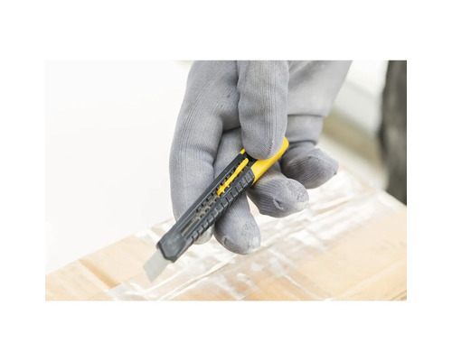 Ruka v rukavici reže pásku na kartónovej krabici nožom