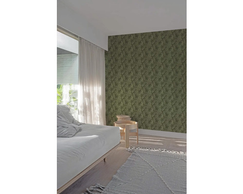 Spálňa s tapetou s listovým vzorom, posteľou, príručným stolíkom a kobercom