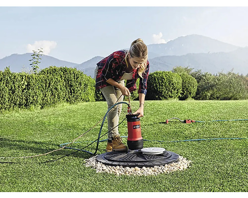 Žena pripája ponorné čerpadlo v záhrade