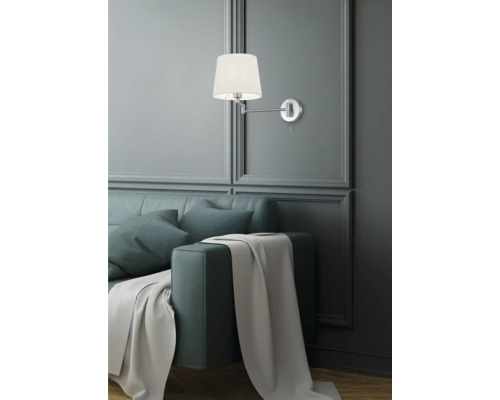 Nástenné svietidlo nad pohovkou s vankúšmi a prikrývkou