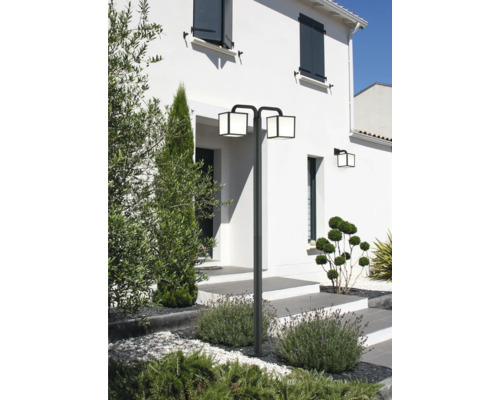 Vonkajší pohľad na dom so záhradou a ozdobnou vonkajšou lampou s dvoma hlavicami.