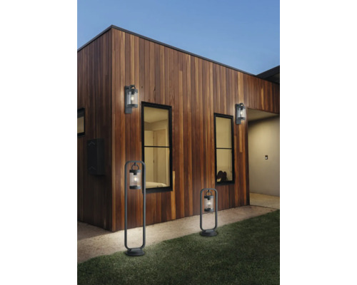 Vonkajší pohľad na dom s drevenou stenou a osvetlenými vonkajšími svetlami