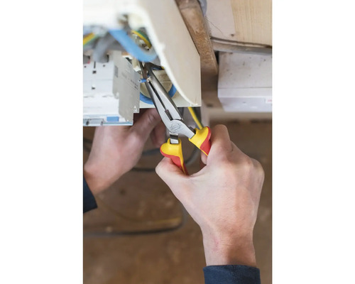 Elektrikár pracuje s kombinovanými kliešťami na elektrickom vedení