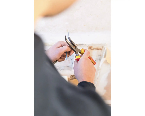 Osoba strihá kábel kliešťami