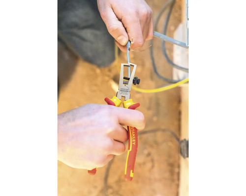 Osoba používa odizolovacie kliešte na odizolovanie kábla.