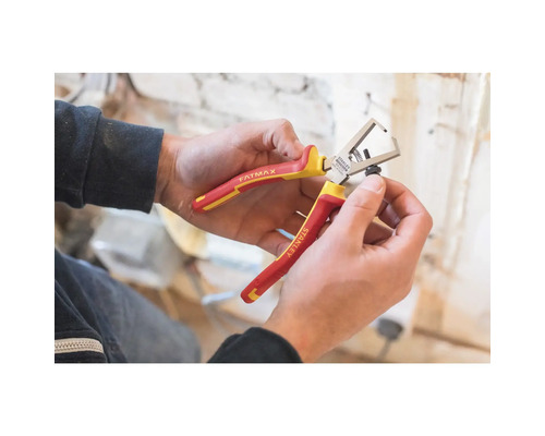 Osoba drží v rukách odizolovacie kliešte Stanley Fatmax.