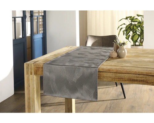 Drevený stôl so šedým behúňom a dekoráciou v interiéri