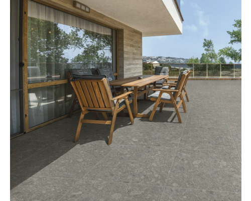 Terasa s dreveným stolom, stoličkami a sivou dlažbou.