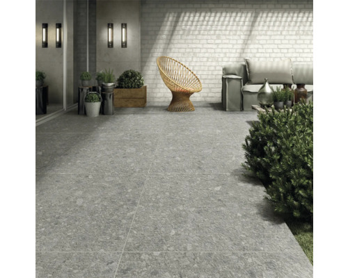 Vonkajší priestor so sivou dlažbou, ratanovým kreslom a sedením