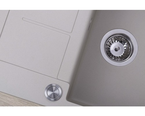 Detailný pohľad na kuchynský drez s odtokom a ovládacím gombíkom