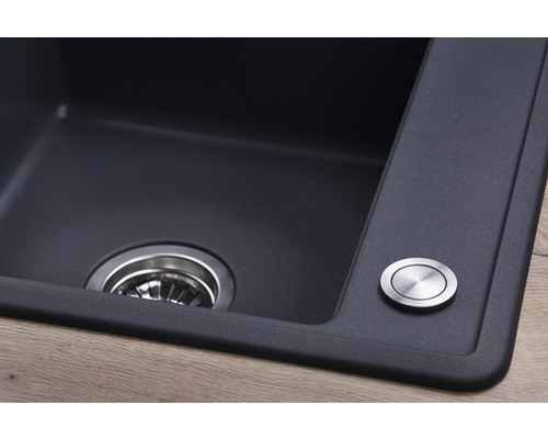 Detailný pohľad na kuchynský drez s odtokom a ovládacím gombíkom