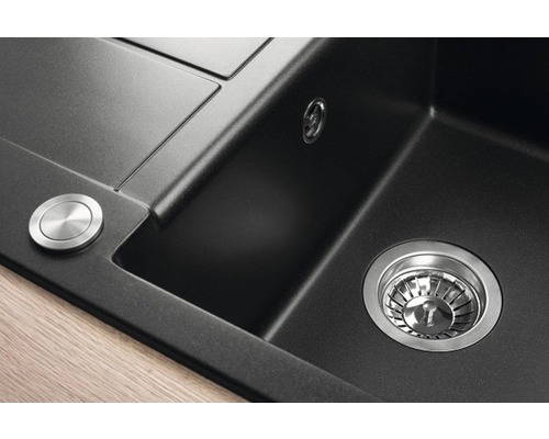 Detailný pohľad na čierny kuchynský drez so sitkovým ventilom a otočným gombíkom