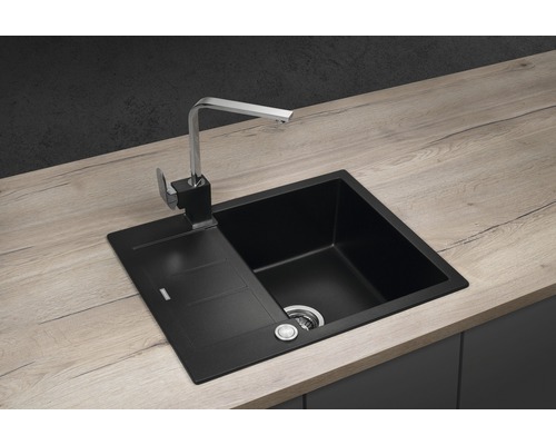 Čierny kuchynský drez s odkvapkávacou plochou a vodovodnou batériou na pracovnej doske