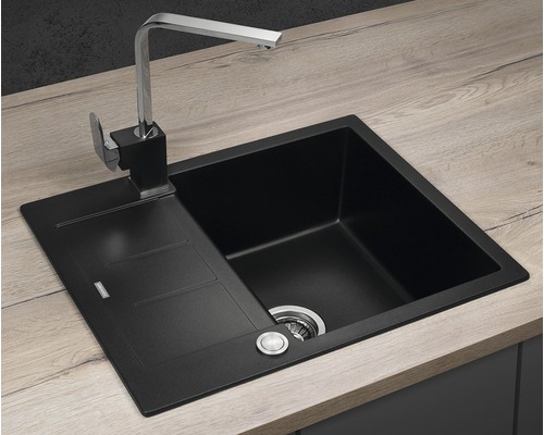 Čierny kuchynský drez s odkvapkávacou plochou a vodovodnou batériou na pracovnej doske