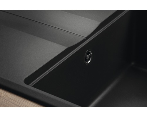 Detailný pohľad na čierny kompozitný kuchynský drez s odtokom