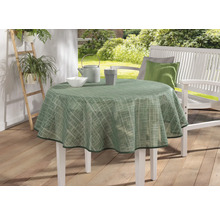 Záhradná scéna s okrúhlym stolom so zeleným obrusom, riadom a bielou záhradnou lavicou