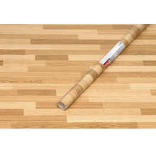 Rolka dizajnovej fólie so vzhľadom dreva na drevenej podlahe