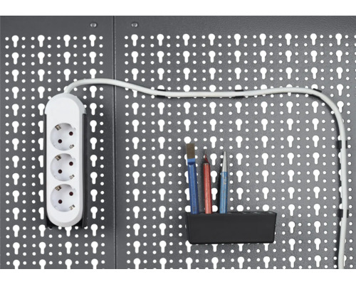 Dierovaná stena na náradie s predlžovacím káblom a náradím v držiaku