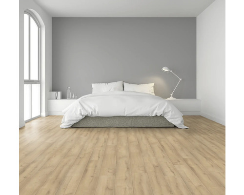 Svetlá spálňa s manželskou posteľou, lampou na nočnom stolíku a laminátovou podlahou