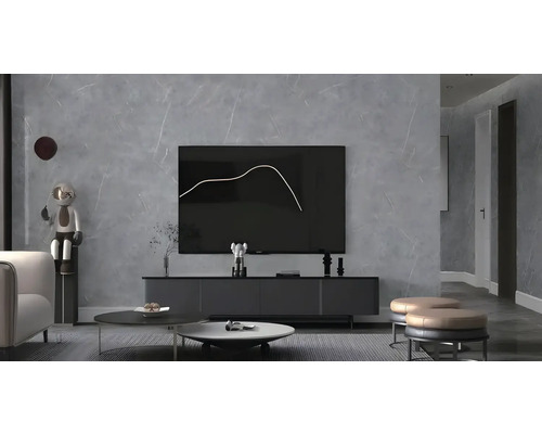 Samolepiaci PVC panel Beton obklad na stenu sivý 120 x 180 cm Moderná obývacia izba s televízorom, konferenčným stolíkom a dekoratívnymi predmetmi.