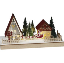 Osvetlená vianočná dekorácia s domami, vianočnými stromčekmi a Santa Clausom v saniach