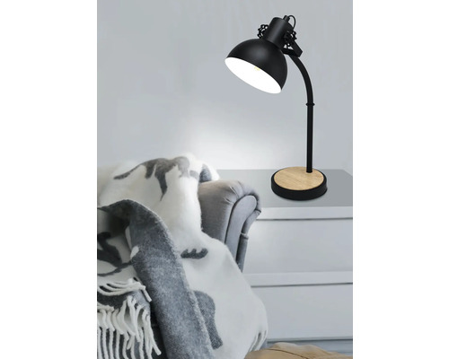 Stolná lampa s drevenou základňou na stole vedľa kresla