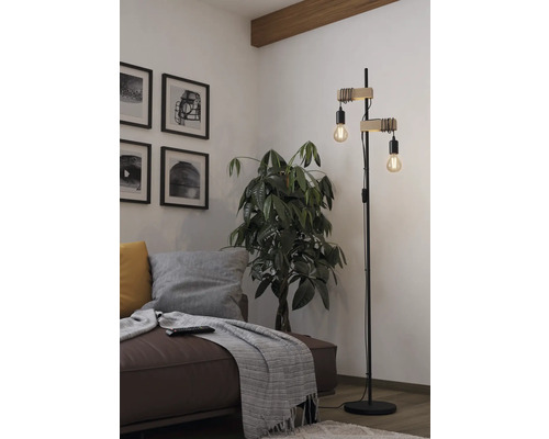 Obývacia izba s pohovkou, izbovou rastlinou a stojacou lampou s dvoma žiarovkami