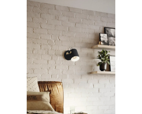 Nástenné svietidlo vedľa pohovky na tehlovej stene