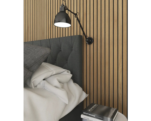 Spálňová scéna s posteľou, nástennou lampou a hromadou kníh