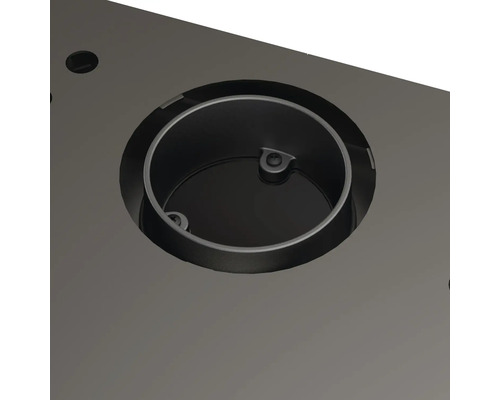 Detailný záber kruhovej kovovej vložky v stolovej doske