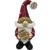 Dekoratívny vianočný škriatok s medovníkom v ruke ako vianočná dekorácia