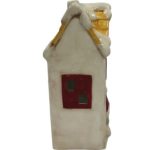 Dekoratívny keramický dom so snehom na streche a komínom.