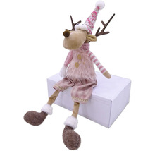 Dekoratívna figúrka soba s čiapkou a šálom, sediaca na bielej krabici.