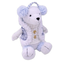 Plyšový medveď s pleteným kabátikom a chráničmi sluchu ako dekorácia