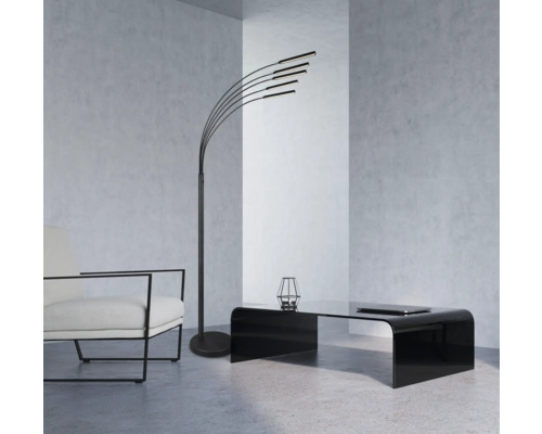 Moderná obývacia izba so stojacou lampou, kreslom a konferenčným stolíkom.