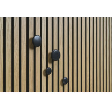 Drevený panel s čiernymi okrúhlymi háčikmi