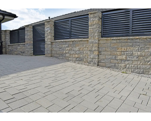 Vonkajšia fotografia s dlažobnými kockami a plotom z kameňa a lamiel.