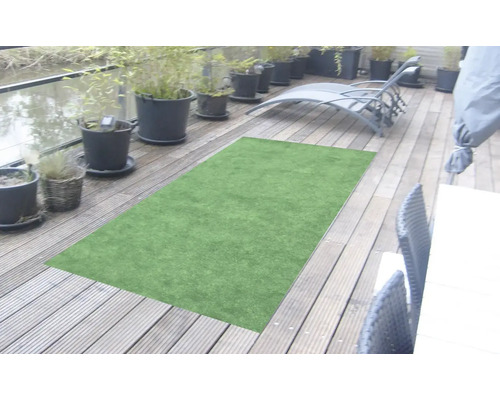 Zelený koberec z umelej trávy na drevenej terase s rastlinami a záhradným nábytkom.