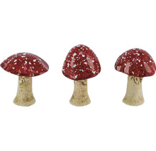 Tri červené muchotrávky s bielymi bodkami ako záhradná dekorácia.