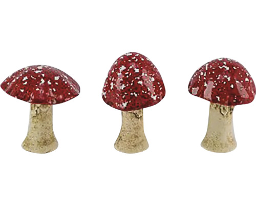 Tri červené muchotrávky s bielymi bodkami ako záhradná dekorácia.