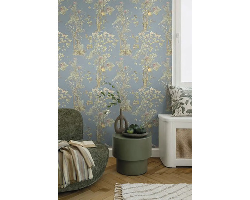 Dekoratívna obývacia izba s kvetinovou tapetou, kreslom a príručným stolíkom.